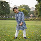 Child in a patterned kurta standing in a park with 'pehnara' branding.